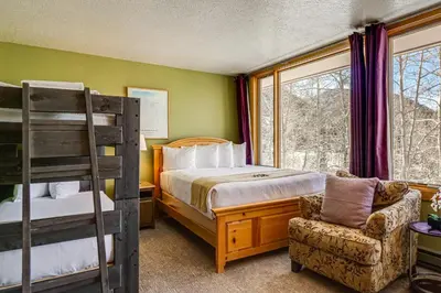 a bedroom with a bunk bed and a chair at Continental Divide Views Lakefront Keystone Condo in Keystone