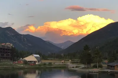 a sunset over a mountain range with a body of water at Continental Divide Views Lakefront Keystone Condo in Keystone