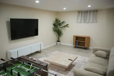 a living room with a tv and a table at Stylish 4BR Getaway, Foosball, Easy Highway Access in Westminster