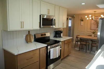 a kitchen with white cabinets and a stove top oven at Stylish 4BR Getaway, Foosball, Easy Highway Access in Westminster