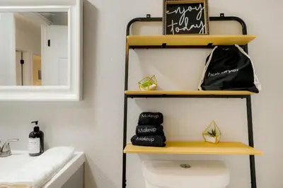 a bathroom with a yellow shelf above a toilet at Family Fun Retreat - Hot Tub & Games in Arvada