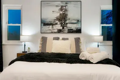 a bedroom with a large bed with two windows at Family Fun Retreat - Hot Tub & Games in Arvada