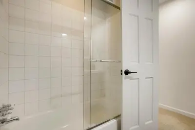 a shower with a glass door next to a tub at Family Fun Retreat - Hot Tub & Games in Arvada