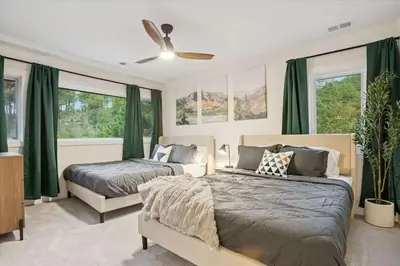 two beds in a bedroom with green curtains at 15 min to Boulder Rope Course Hot Tub & Views in Boulder