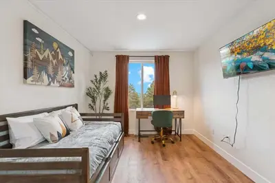 a bedroom with a bed and a desk with a computer at 15 min to Boulder Rope Course Hot Tub & Views in Boulder