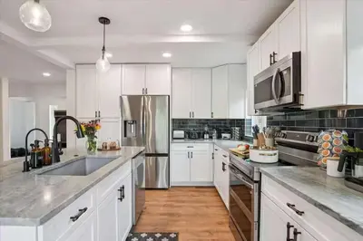 a kitchen with white cabinets and stainless steel appliances at 15 min to Boulder Rope Course Hot Tub & Views in Boulder