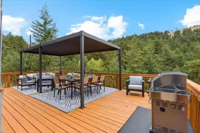 a deck with a table and chairs and a grill at 15 min to Boulder Rope Course Hot Tub & Views in Boulder