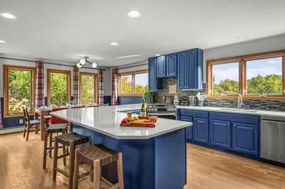 a blue kitchen with a large island with a bowl of fruit at Huge Lodge w Pickleball & More 15 mins to Golden in Arvada