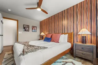 a bedroom with a large bed and a wooden wall at Huge Lodge w Pickleball & More 15 mins to Golden in Arvada