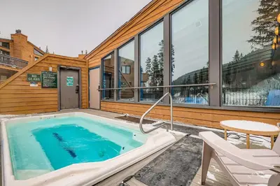 a hot tub on a patio with a table and chairs at 2963 Key Condo condo in Keystone