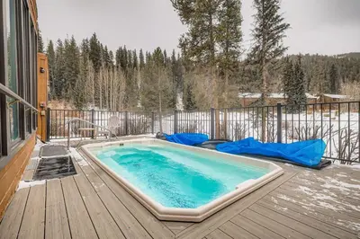 a hot tub on a deck with snow on the ground at 2963 Key Condo condo in Keystone