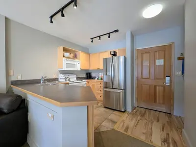 a kitchen with a stainless steel refrigerator and wooden cabinets at Silver Mill 8299 by SummitCove Lodging in Keystone