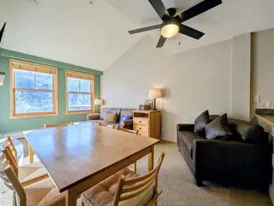 a living room with a table and a ceiling fan at Silver Mill 8299 by SummitCove Lodging in Keystone