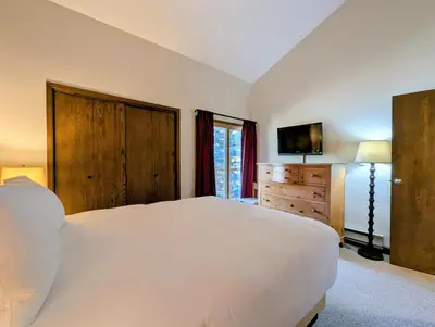 a bedroom with a large white bed and a television at Flying Dutchman 1109 by SummitCove Lodging in Keystone