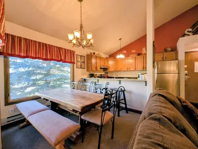 a kitchen and dining room with a table and a couch at Flying Dutchman 1109 by SummitCove Lodging in Keystone