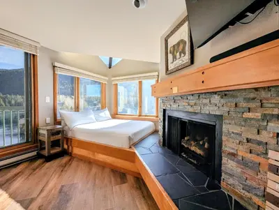 a bedroom with a bed and a fireplace at Lakeside 1491 by SummitCove Lodging in Keystone