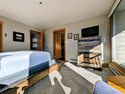 a bedroom with a bed and a flat screen tv at Lakeside 1491 by SummitCove Lodging in Keystone