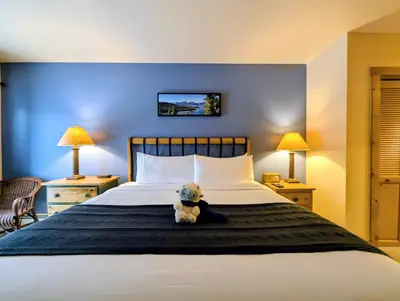 a teddy bear sitting on a bed in a hotel room at Expedition Station 8591 by SummitCove Lodging in Keystone