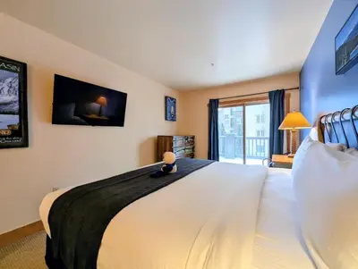 a bedroom with a large white bed with a window at Expedition Station 8591 by SummitCove Lodging in Keystone