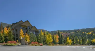 a building on the side of a road with trees at Expedition Station 8591 by SummitCove Lodging in Keystone