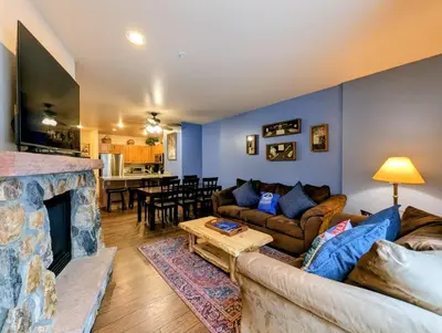 a living room with a couch and a fireplace at Expedition Station 8591 by SummitCove Lodging in Keystone