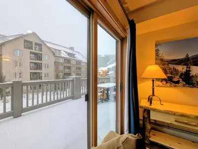 a room with a window with a view of a building at Expedition Station 8591 by SummitCove Lodging in Keystone