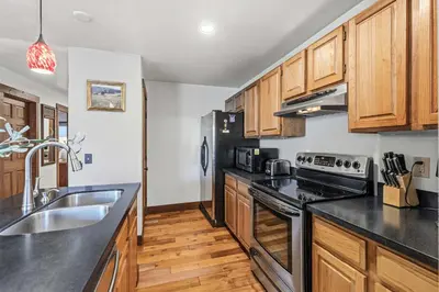 a kitchen with black counter tops and wooden cabinets at 2BR Escape for 6 Overlooking Marina & Lake Dillon in Dillon