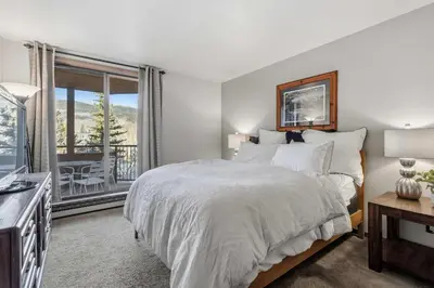 a bedroom with a large bed and a balcony at 2BR Escape for 6 Overlooking Marina & Lake Dillon in Dillon