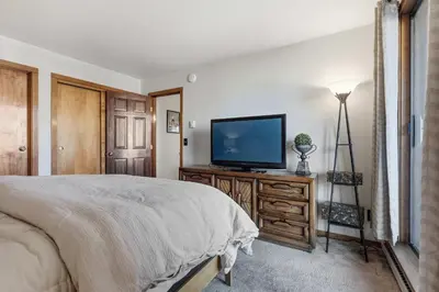 a bedroom with a bed and a flat screen tv at 2BR Escape for 6 Overlooking Marina & Lake Dillon in Dillon