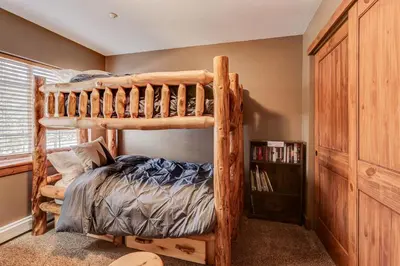 a bedroom with a bunk bed and a book shelf at Breckenridge 2BR Ski and Mountain Adventure Base in Breckenridge