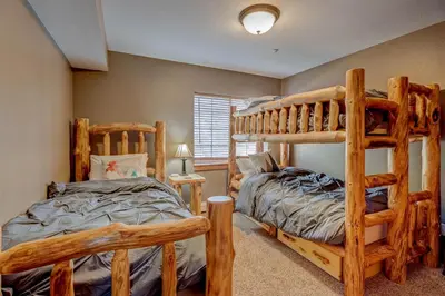 two wooden bunk beds in a bedroom with a bed at Breckenridge 2BR Ski and Mountain Adventure Base in Breckenridge