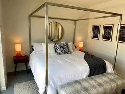 a bedroom with a canopy bed with a mirror at Beautiful Pearl Street condo! 30 DAY MINIMUM STAY in Boulder