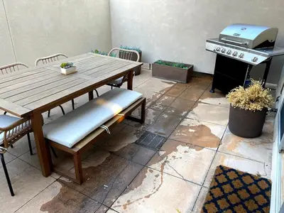 a patio with a table and chairs and a grill at Beautiful Pearl Street condo! 30 DAY MINIMUM STAY in Boulder