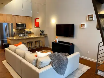 a living room with a couch and a kitchen at Beautiful Pearl Street condo! 30 DAY MINIMUM STAY in Boulder