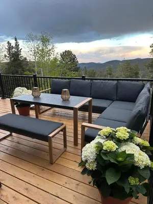 a patio with a couch and tables on a deck at Modern Chalet w Hot Tub, Views, Putting Green in Evergreen