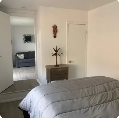 a white bedroom with a bed and a couch at My hidden gem in Denver