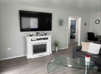 a living room with a television above a fireplace at Lovely 2 bedroom unit with a hot tub Pet friendly in Denver