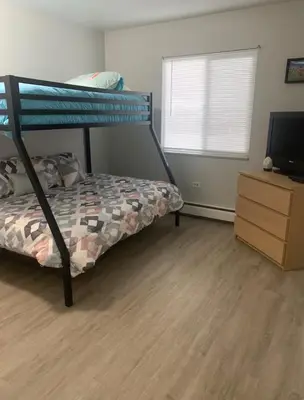 a bedroom with a bunk bed and a dresser with a television at Lovely 2 bedroom unit with a hot tub Pet friendly in Denver
