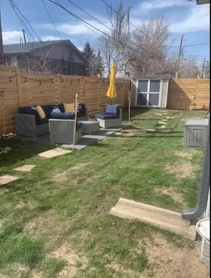 a backyard with two couches and an umbrella at Lovely 2 bedroom unit with a hot tub Pet friendly in Denver