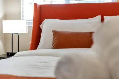 a bed with an orange headboard and a pillow at 5 Bed/ Pickle360/ Basketball/ Movie in Thornton