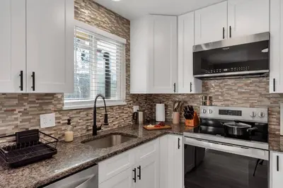 a kitchen with white cabinets and a sink at 5 Bed/ Pickle360/ Basketball/ Movie in Thornton