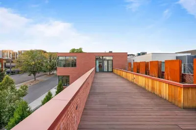 a wooden walkway leading to a brick building at LoHi Luxury Modern House — Walk to Everywhere in Denver