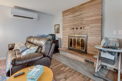 a living room with a leather couch and a fireplace at 3 Mi to Dtwn Berthoud Home with Longs Peak Views in Berthoud