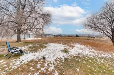 a chair sitting in a field covered in snow at 3 Mi to Dtwn Berthoud Home with Longs Peak Views in Berthoud