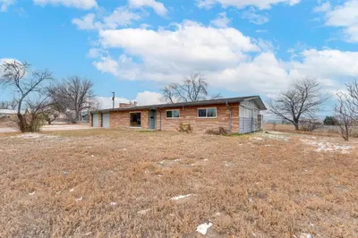 an old brick house in a field with a grass field at 3 Mi to Dtwn Berthoud Home with Longs Peak Views in Berthoud
