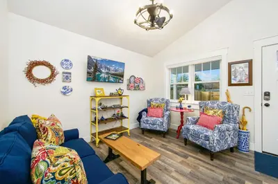 a living room with a blue couch and two chairs at City Park Bungalow Pet Friendly with Dog Run in Fort Collins