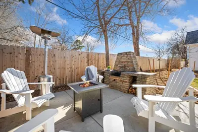 a patio with white chairs and a fire pit at City Park Bungalow Pet Friendly with Dog Run in Fort Collins