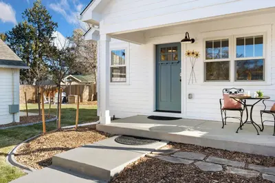 a white house with a blue door and a table at City Park Bungalow Pet Friendly with Dog Run in Fort Collins