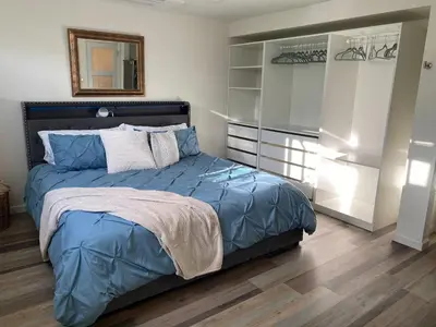 a bedroom with a bed with a blue comforter and a mirror at Apartment in Ft Collins in Fort Collins