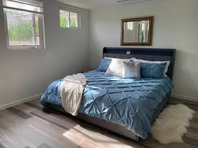 a bedroom with a bed with a mirror and a rug at Apartment in Ft Collins in Fort Collins